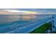 Stunning beach view at sunset with crystal blue water and palm trees lining the coast at 1000 Longboat Club Road # 1105, Longboat Key, FL 34228