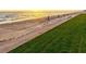 Seaside property with beach access featuring lounge chairs and sun umbrellas along the grassy lawn at 1000 Longboat Club Road # 1105, Longboat Key, FL 34228
