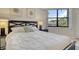 Comfortable bedroom featuring a large window with natural light and a view of the lush greenery outside at 1000 Longboat Club Road # 1105, Longboat Key, FL 34228