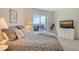 Bright bedroom featuring a balcony, TV, neutral carpet, and tasteful decor at 1000 Longboat Club Road # 1105, Longboat Key, FL 34228