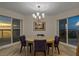 This modern dining area has a chandelier and ocean views from the windows on either side at 1000 Longboat Club Road # 1105, Longboat Key, FL 34228