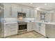 Bright kitchen featuring white cabinets, stainless steel appliances, and stone backsplash and wood flooring at 1000 Longboat Club Road # 1105, Longboat Key, FL 34228