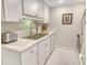 Bright kitchen featuring white cabinets, stainless steel appliances, and marble countertops and tile at 1000 Longboat Club Road # 1105, Longboat Key, FL 34228