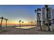 Beautiful pool reflecting sunrise, palm trees, and beachfront condo at 1000 Longboat Club Road # 1105, Longboat Key, FL 34228