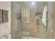 Shower features glass doors, gray tiling, and built in shelves at 1000 Longboat Club Road # 1105, Longboat Key, FL 34228