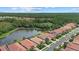 Aerial view of a neighborhood featuring lush green space, a tranquil lake, and well-manicured homes at 11550 Blackfin St, Venice, FL 34292
