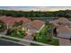 Overhead view of homes with terracotta roofs situated near a tranquil lake and green landscape at sunset at 11550 Blackfin St, Venice, FL 34292