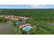 Aerial view of a community with a pool, surrounded by lush greenery and tranquil waterfront views at 11550 Blackfin St, Venice, FL 34292
