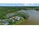 A scenic aerial view of a lakefront property with a community pool, surrounded by verdant foliage and calm waters at 11550 Blackfin St, Venice, FL 34292