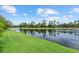 Picturesque lake view with lush green grass, mature trees, and calm waters offering a serene ambiance at 11550 Blackfin St, Venice, FL 34292