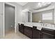 Bathroom featuring double sink vanity with dark wood cabinets, large mirrors, and ample lighting at 11550 Blackfin St, Venice, FL 34292