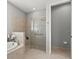 Bathroom showcasing a glass-enclosed shower, soaking tub, and neutral tile work at 11550 Blackfin St, Venice, FL 34292