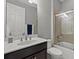 Bathroom featuring a vanity, toilet, and shower-tub combo with glass doors, offering a functional space at 11550 Blackfin St, Venice, FL 34292