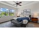 Calm bedroom featuring a cozy bed, tray ceiling, and a large window providing natural light and outdoor views at 11550 Blackfin St, Venice, FL 34292