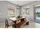 Dining room with a wooden table, bench seating, and views of the backyard pool at 11550 Blackfin St, Venice, FL 34292