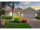 Charming home featuring a beautiful landscaped yard with mature palm trees and a brick driveway at 11550 Blackfin St, Venice, FL 34292