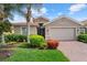 Charming single-story home featuring a well-manicured lawn, mature landscaping and a paver driveway at 11550 Blackfin St, Venice, FL 34292
