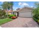 Inviting single-story home with a beautiful lawn, mature landscaping, and a brick paver driveway at 11550 Blackfin St, Venice, FL 34292