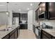 Kitchen featuring stainless steel appliances, dark wood cabinets and granite countertops at 11550 Blackfin St, Venice, FL 34292