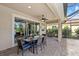 Outdoor patio with a dining table, ceiling fan, and access to a screened pool area at 11550 Blackfin St, Venice, FL 34292