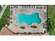 Aerial view of a uniquely shaped community pool surrounded by lounge chairs and manicured grounds at 11550 Blackfin St, Venice, FL 34292