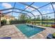 Screened pool with brick patio, a spa, and a serene lake view, perfect for relaxation and enjoying the outdoors at 11550 Blackfin St, Venice, FL 34292