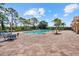 Community pool area featuring ample seating, brick pavers, and lush landscaping for a luxurious experience at 11550 Blackfin St, Venice, FL 34292