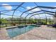 Backyard pool offers a covered spa, brick patio, and views of a tranquil lake at 11550 Blackfin St, Venice, FL 34292
