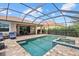 Covered patio and screened pool with brick, spa, and outdoor dining set, ideal for entertaining and outdoor living at 11550 Blackfin St, Venice, FL 34292