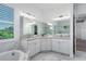 Elegant bathroom featuring dual sinks, a soaking tub, and decorative mirrors at 15808 42Nd E Gln, Parrish, FL 34219