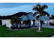 Beautiful home exterior with a three-car garage, tropical landscaping, and a paver driveway at 15808 42Nd E Gln, Parrish, FL 34219