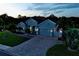 Aerial view showcasing home with a paved driveway and a three-car garage, nestled among palm trees at 15808 42Nd E Gln, Parrish, FL 34219