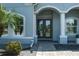 Close-up of home's front entrance with decorative glass doors, manicured landscaping, and detailed architectural accents at 15808 42Nd E Gln, Parrish, FL 34219