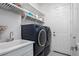 Laundry room featuring modern washer and dryer with overhead storage and access to the exterior at 15808 42Nd E Gln, Parrish, FL 34219