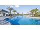 Community pool featuring lounge chairs, umbrellas, lush landscaping, and a clear blue swimming pool at 16415 Star Grass Cir, Bradenton, FL 34211