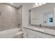Modern bathroom featuring gray tiled walls, granite countertop, and updated fixtures at 18068 Cherished Loop, Bradenton, FL 34211