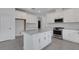 Spacious kitchen with white cabinets, stainless steel appliances, and granite countertops on a large island at 18068 Cherished Loop, Bradenton, FL 34211