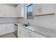 Well-lit kitchen with white cabinets, granite countertops, and stainless steel sink at 18068 Cherished Loop, Bradenton, FL 34211
