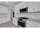 Contemporary kitchen with white cabinets, stainless steel appliances, and granite countertops at 18068 Cherished Loop, Bradenton, FL 34211