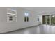 Bright living room with tile flooring, multiple windows, and sliding door to patio at 18068 Cherished Loop, Bradenton, FL 34211