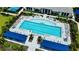 An aerial view shows a sparkling community pool with ample seating, surrounded by lush landscaping and shade at 18068 Cherished Loop, Bradenton, FL 34211