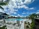 Community pool surrounded by lounge chairs and manicured landscaping under a blue sky at 18068 Cherished Loop, Bradenton, FL 34211