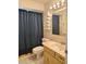 Bathroom featuring a single sink vanity, toilet, and shower with a blue curtain at 2004 40Th W St, Bradenton, FL 34205