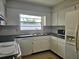 Kitchen with white cabinets and appliances, featuring a window with a view at 2004 40Th W St, Bradenton, FL 34205