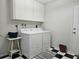 Laundry room with washer, dryer, overhead cabinets, and black and white floor at 2004 40Th W St, Bradenton, FL 34205