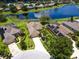 Aerial view of a residential neighborhood showcasing houses with pools, lush landscaping, and a beautiful lake at 280 Dahlia Ct, Bradenton, FL 34212