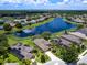 Gorgeous aerial view of homes surrounding a pristine lake with beautiful landscaping and blue skies at 280 Dahlia Ct, Bradenton, FL 34212