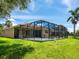 Spacious backyard showcasing a screened-in pool area, lush green lawn, and well-maintained landscaping at 280 Dahlia Ct, Bradenton, FL 34212