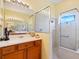 Bathroom featuring a walk-in shower, white countertop vanity, and a large framed mirror giving the room a spacious feel at 280 Dahlia Ct, Bradenton, FL 34212