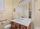 Bathroom with tile floors, a walk-in shower behind glass, and wood cabinets with a white countertop sink at 280 Dahlia Ct, Bradenton, FL 34212